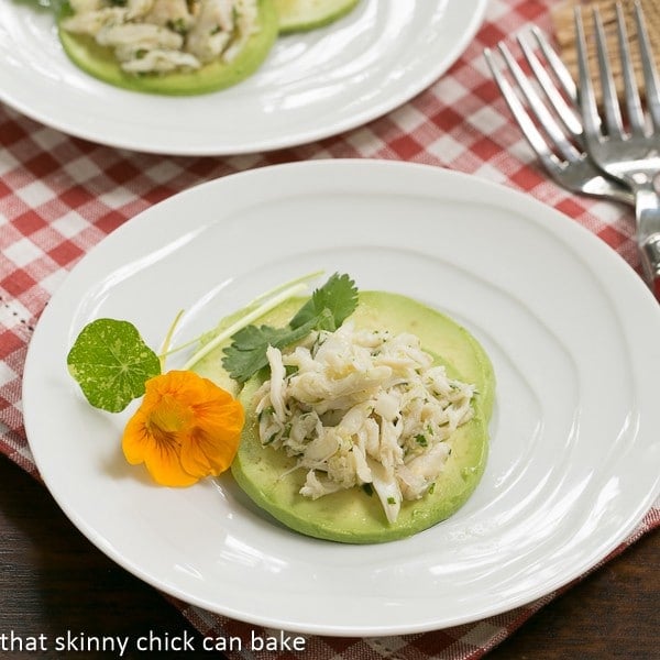 Crab Avocado Ravioli slices on a white plate with a flower garnish