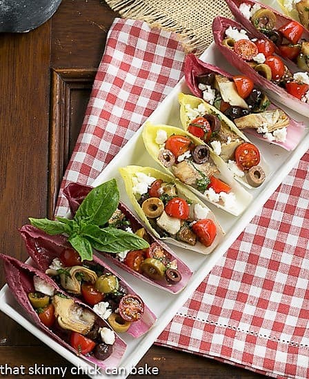 Mediterranean Endive Boats - a fun, bite sized salad or appetizer A tray of endive boats on a red and white checked napkin.