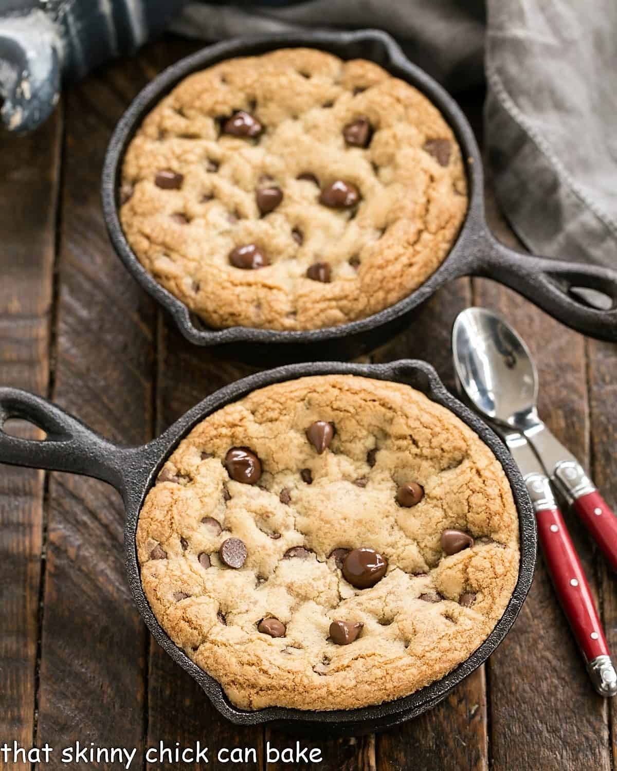Homemade Pizookies Recipe - Big gooey pan cookies that are a cross between cookies and pan pizza! Overhead view of 2 pizza cookies in cast iron skillets.
