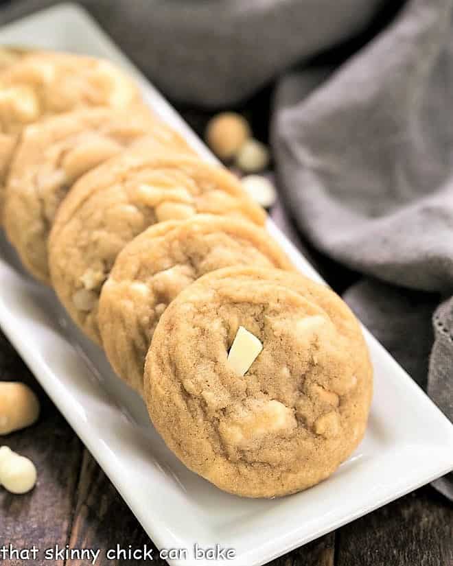 White Chocolate Macadamia Nut Cookies - The quintessential macadamia nut cookie recipe that will have you swooning!!! White Chocolate Macadamia Nut Cookies on a white ceramic tray.