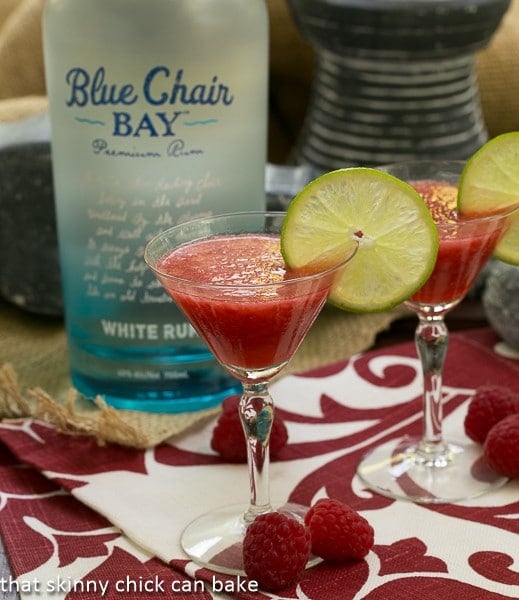 Frozen Fresh Berry Daiquiris in front of a bottle of rum