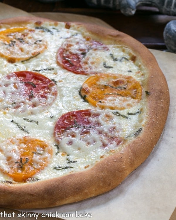 Pizza Margherita fresh out of the oven on a sheet of parchment.
