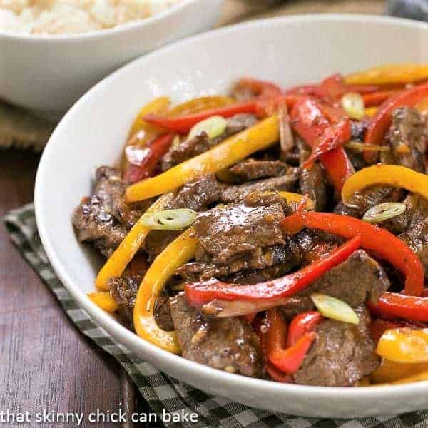 Asian Beef with Peppers in a white serving bowl.