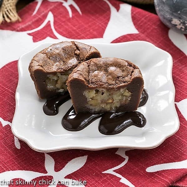 German Chocolate Brownie Cupcakes - cupcake sized brownies filled with gooey coconut filling German Chocolate Brownie Cupcakes on a white dessert plate drizzled with fudge sauce.