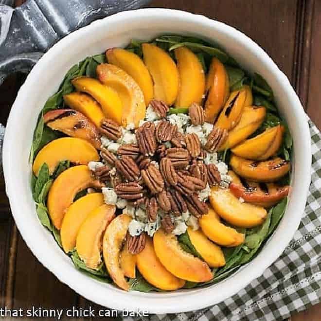Spinach Salad with Grilled Peaches and Blue Cheese - a delicious summer salad using fresh, juicy peaches! Overhead view of a bowl of Spinach Salad with Grilled Peaches and Blue Cheese