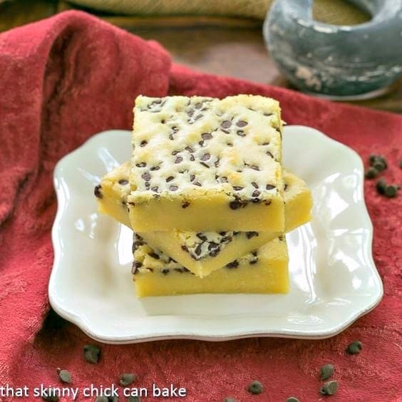 White Chocolate Brownies - White chocolate lovers will go nuts for these dense, delicious "brownies!" White Chocolate Brownies stacked on a white plate.