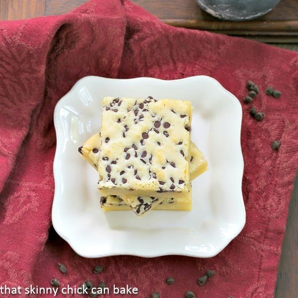White Chocolate Brownies - White chocolate lovers will go nuts for these dense, delicious "brownies!" Overhead view of White Chocolate Brownies stacked on a white dessert plate.