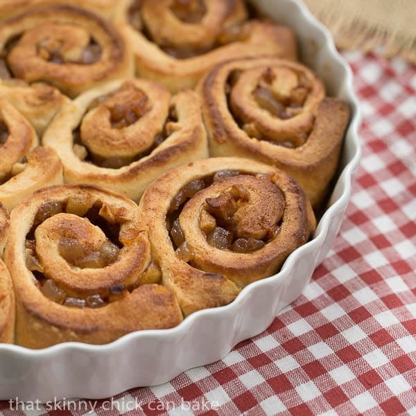 Unfrosted Apple Cinnamon Rolls in a round white baking dish.