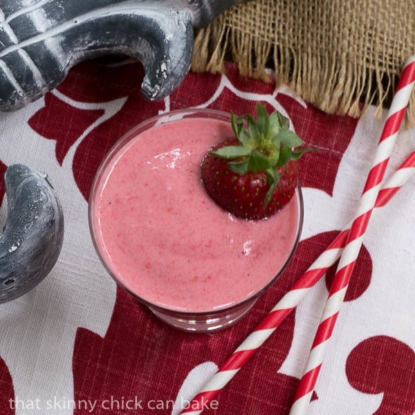 Overhead view of a Berry Smoothie with two red and white straws.