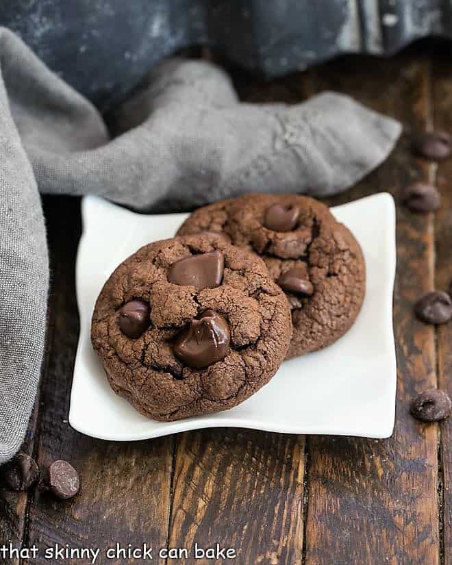 Two Double Chocolate Chunk Cookies on a square white plate.