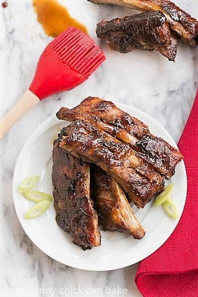 Asian Baby Back Ribs - Finger licking good with a seriously delicious glaze! Overhead view of Oven Baked Asian Baby Back Ribs on a small white plate.