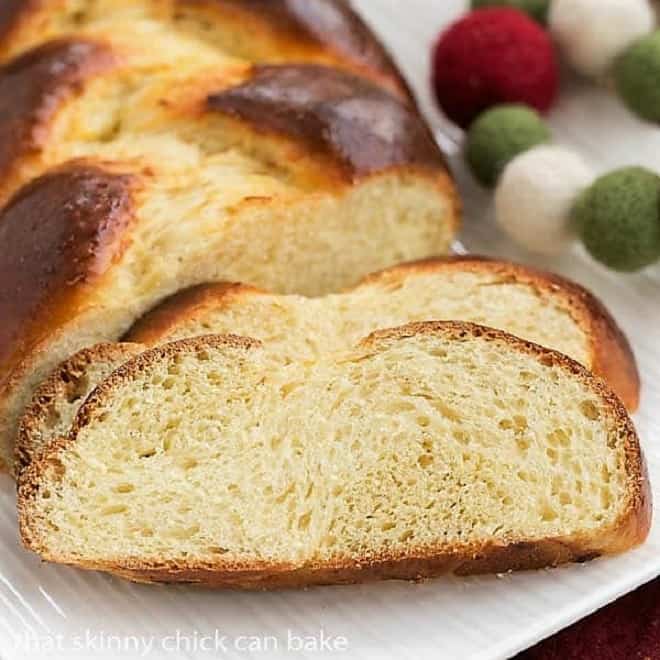 Swiss butter braid is a slightly sweet, plaited, special occasion bread, perfect for the holidays, entertaining or for a special treat. Crank up your oven a bake a loaf of this magnificent Swiss butter braided bread recipe, also known as Butterzopf. #bread #recipe #holidaybaking slices of tender Swiss Butter Braid (Butterzopf) on a white platter.