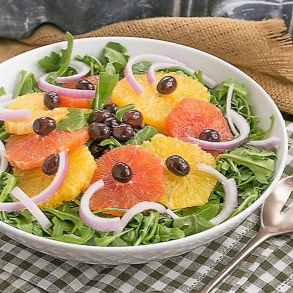 Orange Olive Salad on a bed of arugula in a white bowl.