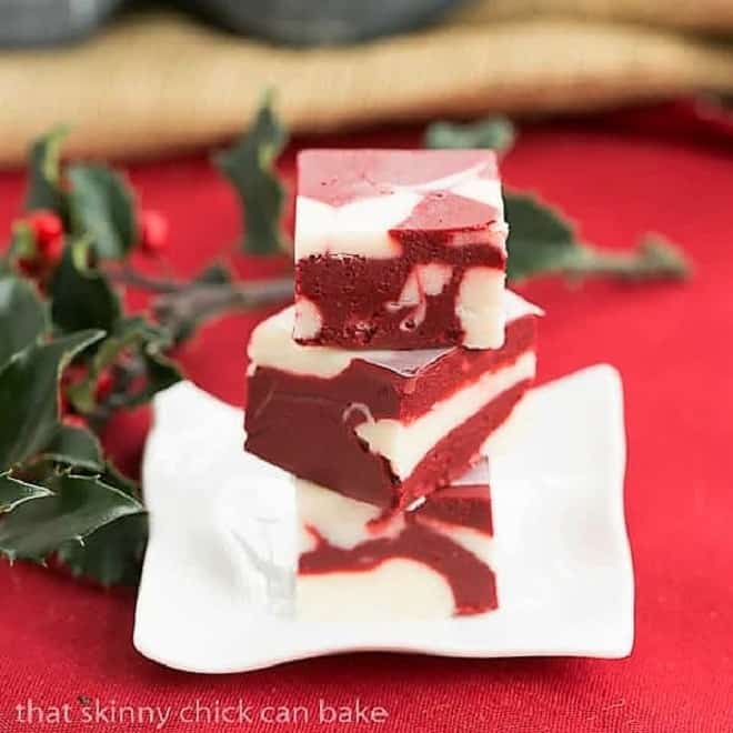 Red Velvet Fudge - This marbleized fudge will make you swoon! This easy fudge recipe is perfect for the holidays! Red Velvet Fudge on a small square rippled plate.