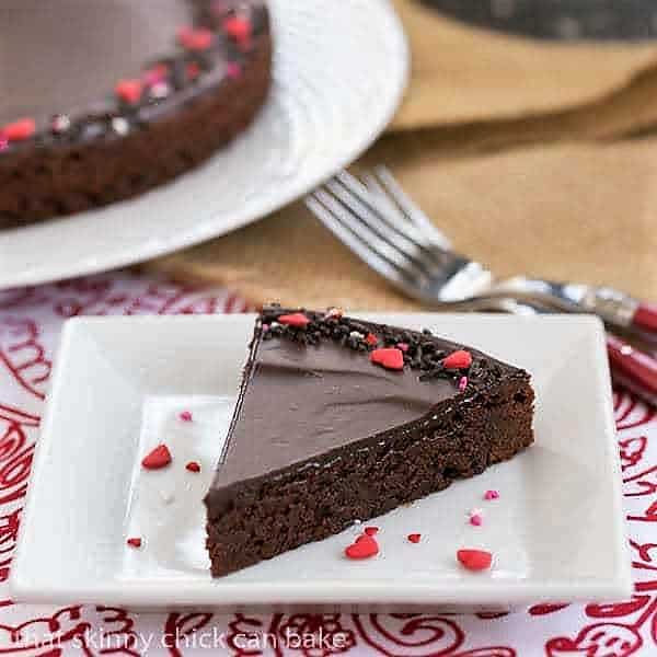 These rich, Ganache Topped Truffle Brownies are the perfect treat for when those chocolate cravings hit! A wedge of Ganache Topped Truffle Brownies on a square white plate.