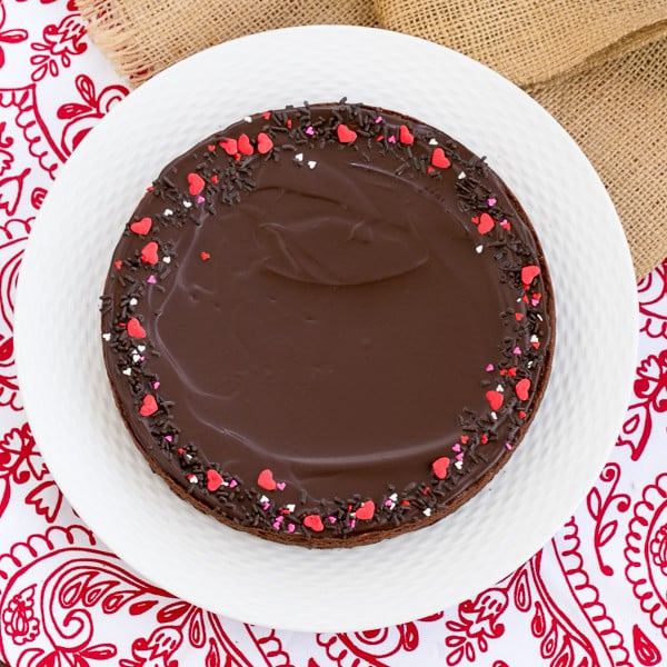 These rich, Ganache Topped Truffle Brownies are the perfect treat for when those chocolate cravings hit! Ganache Topped Truffle Brownies on a white ceramic plate.