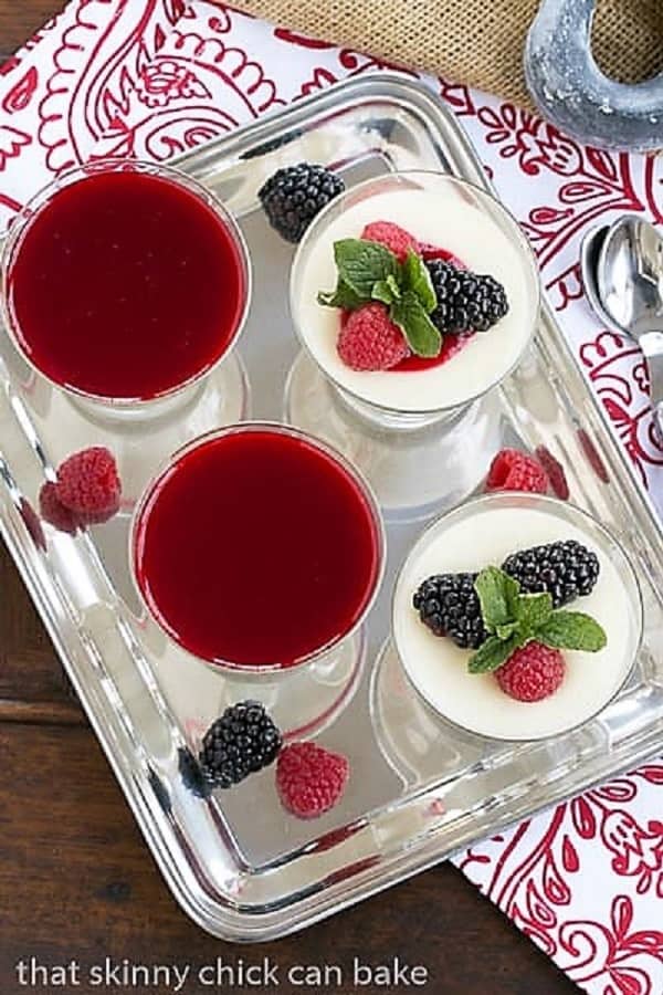 White Chocolate Panna Cotta - topped with a raspberry sauce or berries for an elegant Italian dessert Overhead view of Vanilla Bean Panna Cotta on a silver tray.