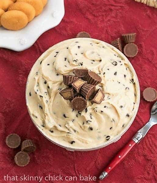 Overhead view of Tagalong dip in a serving bowl topped with mini Reeses peanut butter cups.