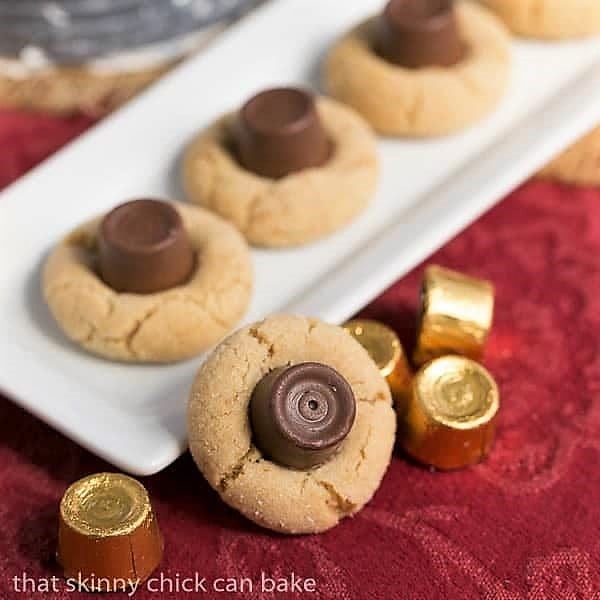 Rolo Peanut Blossoms - Sugar coated peanut butter cookies topped with a chocolate caramel Rolo candy #cookies #peanutbuttercookies #peanutblossoms #Rolos #caramel #holidaycookies #cookieexchange #thatskinnychickcanbake Peanut Butter Rolo Blossoms on a white ceramaic tray