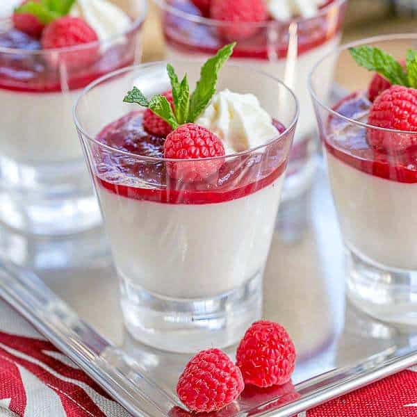 Close view ofRaspberry White Chocolate Cheesecake Parfaits on a silver tray.