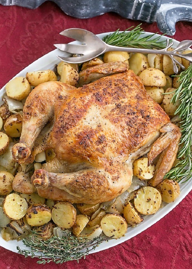 Classic Roast Chicken with Mustard Potatoes on an oval platter.