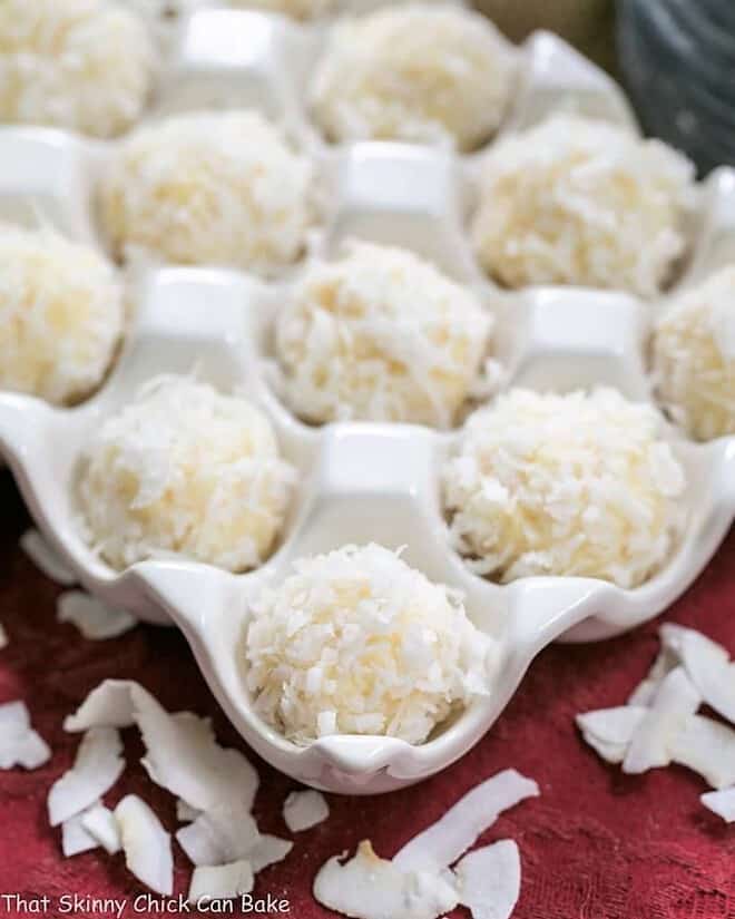 Coconut White Chocolate Truffles - An easy, decadent 4 ingredient recipe! Perfect for gifts! Close view of Coconut White Chocolate Truffles in a ceramic egg crate.