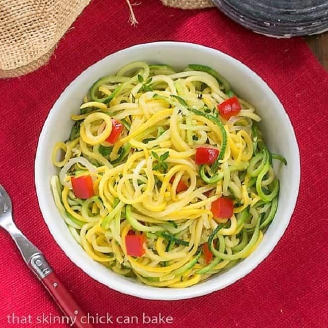 Zucchini Noodles with Parmesan - A light, healthy, low carb side dish! Zucchini Noodles with Parmesan in a white bowl on a red napkin.