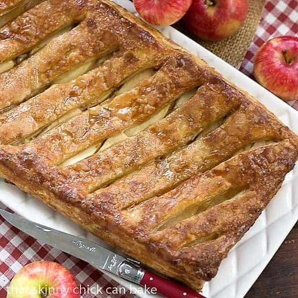 Maple Glazed Apple Tart - Puff pastry, sweetened cream cheese, apples and a maple glaze make for a spectacular breakfast or dessert Overhead view of glazed apple tart on a red and white napkin.