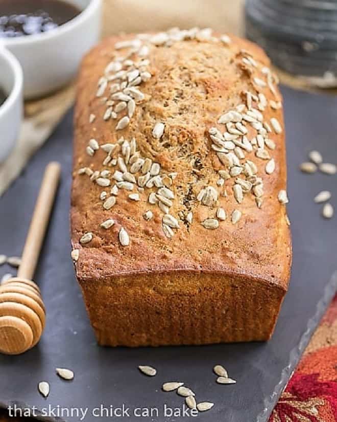 Sunflower Whole Wheat Bread - A whole wheat quick bread with oats, buttermilk and sunflower seeds! Loaf of Sunflower Whole Wheat Bread on a slate tray.