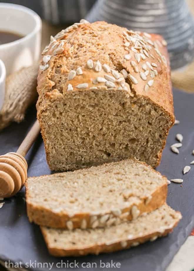 Sunflower Whole Wheat Bread - A whole wheat quick bread with oats, buttermilk and sunflower seeds! Loaf and Sliced Sunflower Whole Wheat Bread on a slate tray