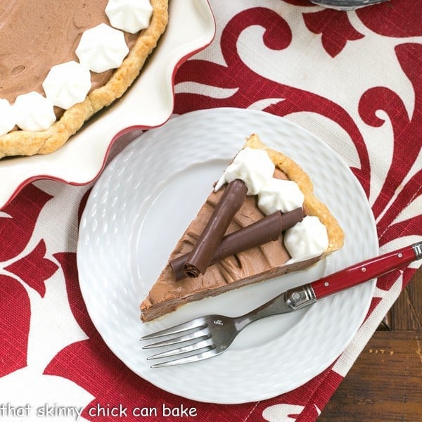A slice of Classic French Silk Pie on a plate on a red and white napkin.