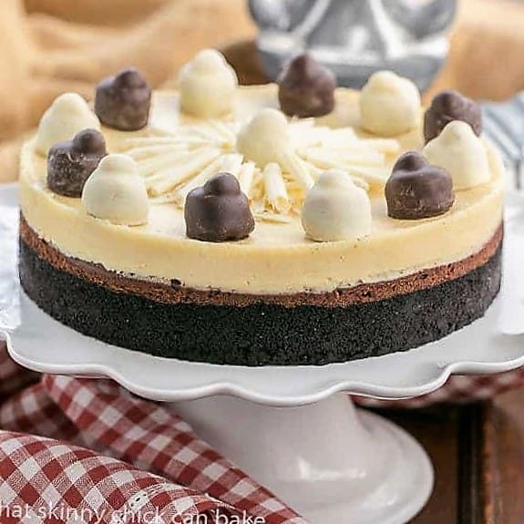 Layered Chocolate Cheesecake on a white cake stand.