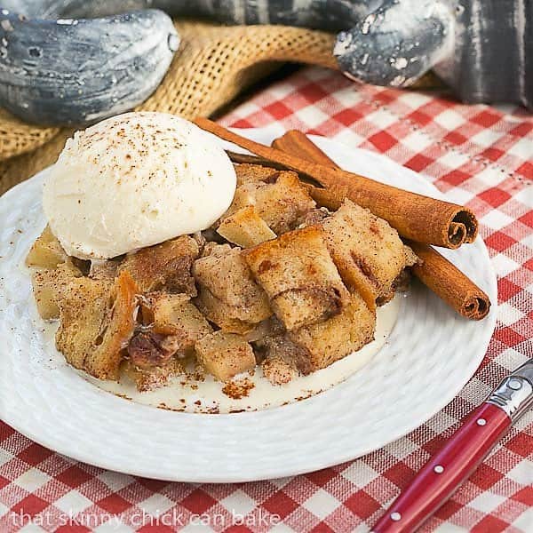 Slow Cooker Apple Pecan Bread Pudding side view on a white plate over a checked napkin