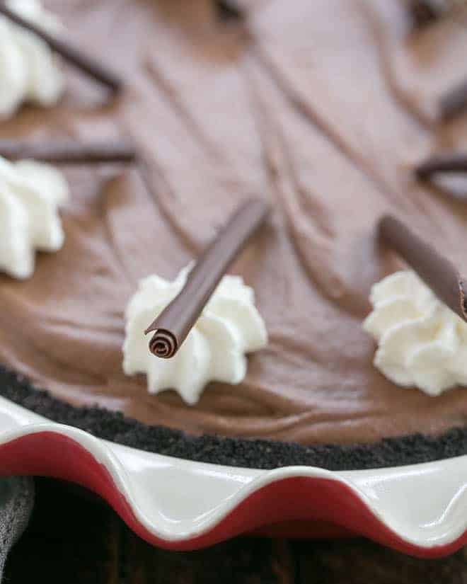 The Best French Silk Pie Recipe - A decadent, luscious chocolate pie with a Frangelico twist! Close up of Frangelico French Silk Pie garnishes of whipped cream and chocolate curls.