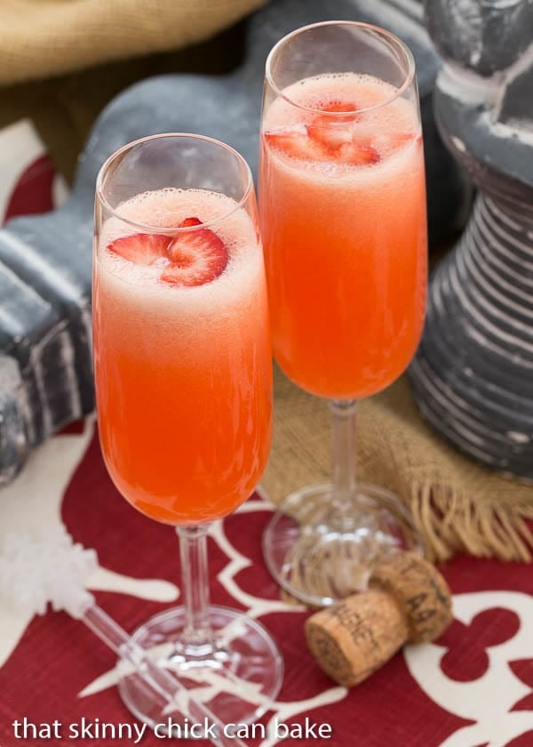 Peach Bellini cocktails in flutes with fresh strawberry slices