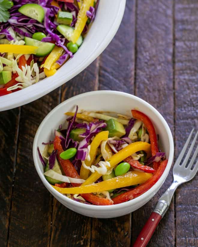 Thai Salad - A vibrant, crunchy salad with a peanut dressing Overhead view of small bowl of Thai salad next to the serving bowl.