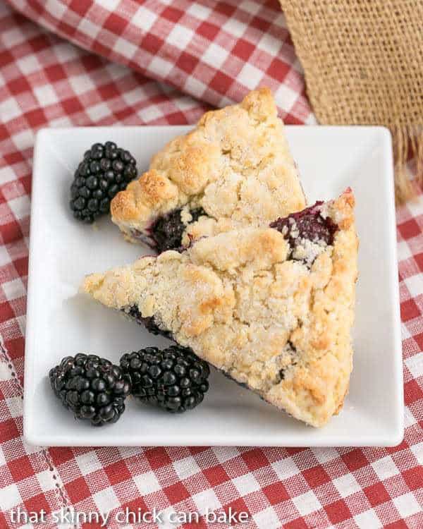 Fresh Blackberry Scones with Cream - Moist, scrumptious and packed full of berries Overhead view of 2 of the best scones recipe with blackberries on a white plate.