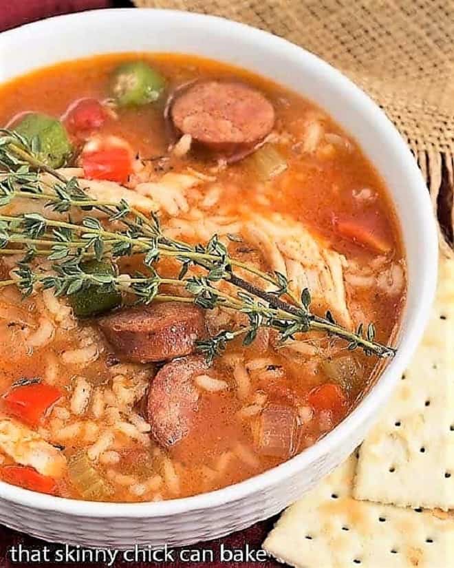 Bowl of Chicken Jambalaya Soup topped with a sprig of thyme