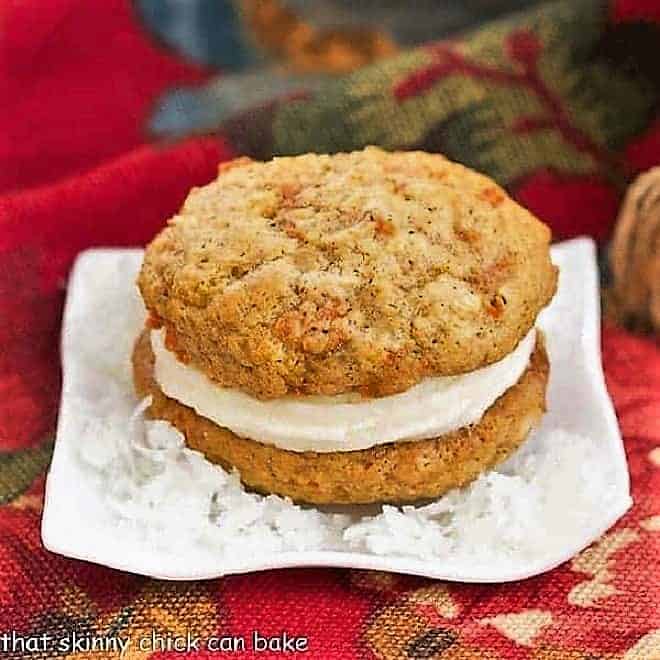 Carrot Cake Whoopie Pies - All the magnificent flavors my from my easy carrot cake recipe in these fabulous whoopie pies Carrot Cake Whoopie Pie sitting on a bed of flaked coconut.