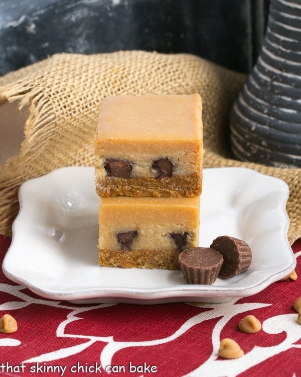 Peanut Butter Cheesecake Bars stacked on a square white dessert plate.