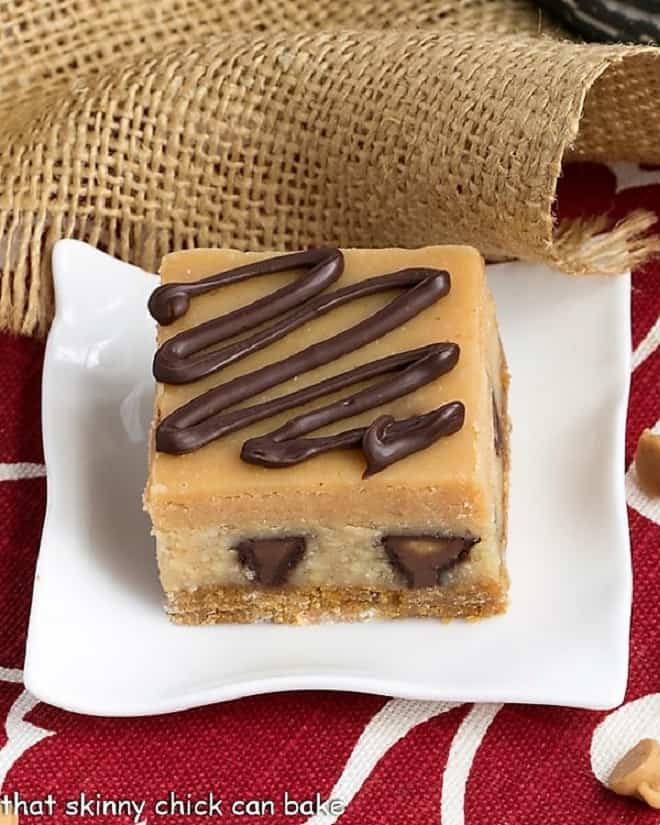 Peanut Butter Cheesecake Bars on a white square dessert plate.