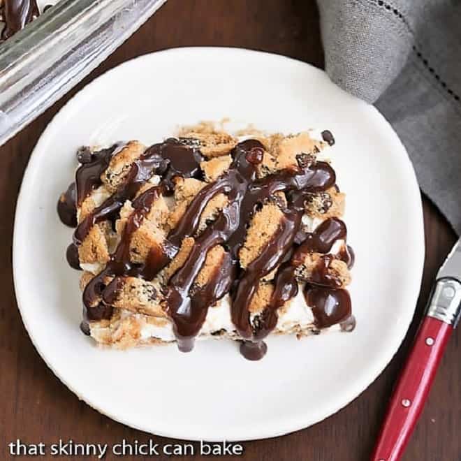 Milk & Cookies Lasagna - A dreamy, decadent layered, no-bake dessert! A slice of Milk & Cookies Lasagna on a round white plate with red handled fork.