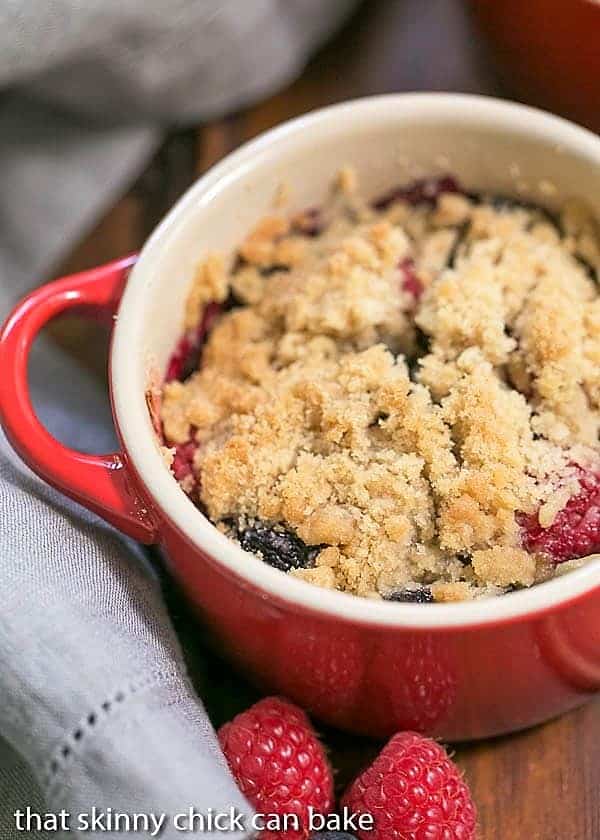 Overhead view of an Individual Berry Crisp in a red ceramic baking dish.