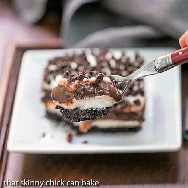 Chocolate Lasagna - A cool, decadent layered chocolate extravaganza! Forkful of Chocolate Lasagna| in front of a slice on a square white plate