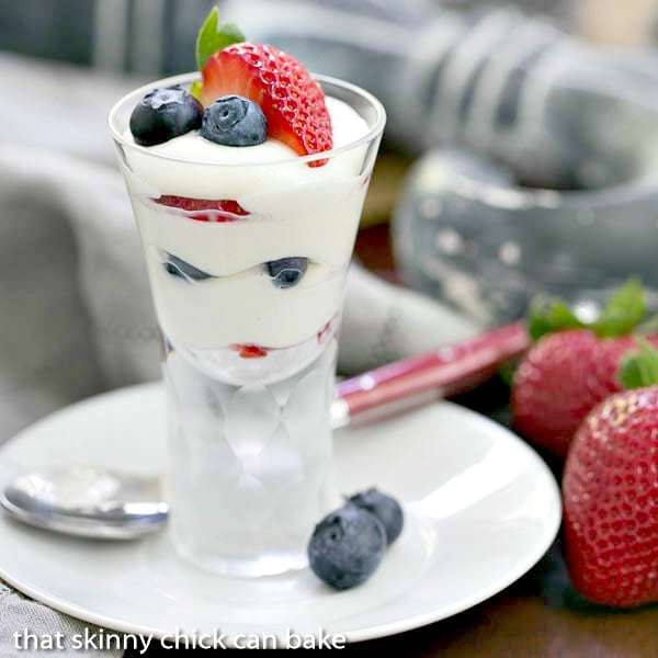 White Chocolate Berry Parfaits on a small plate with blueberries and strawberrie to garnish