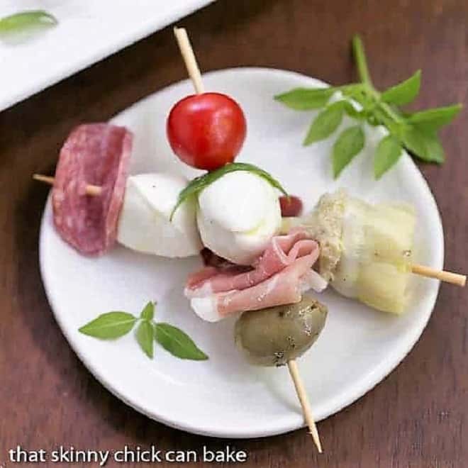 Antipasto Skewers - An easy twist on the Italian appetizer Antipasto Skewers crossed on a round white plate.