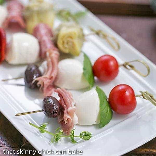Antipasto Skewers - An easy twist on the Italian appetizer Close up of Antipasto Skewers on a white tray.