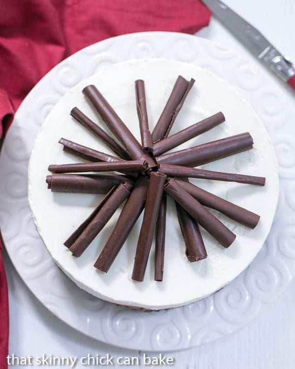 Triple Chocolate Mousse Pie overhead view on a white ceramic plate garnished with chocolate curls