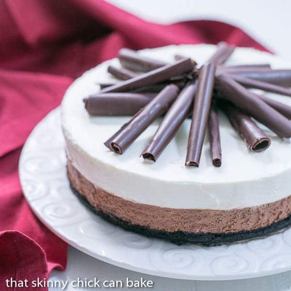 Triple Chocolate Mousse Pie - A dreamy pie topped with both dark and white chocolate mousse Triple Chocolate Mousse Pie on a white serving plate with a red napkin.