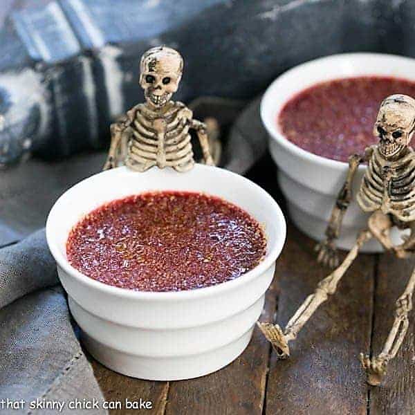 Bloody Crème Brûlée - The classic vanilla custard with burnt sugar topping and a ghoulish twist! Bloody Creme Brulee in white ramekins.